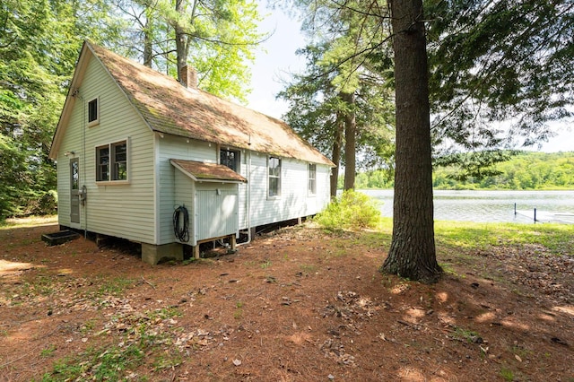 31 Sherene Orchard Rd, Meredith, NH 03253 - view of home's exterior with a chimney, roof with shingles, and a water view