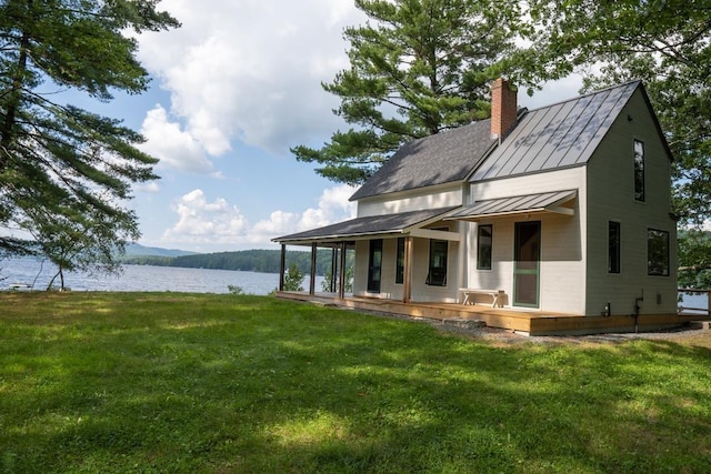 518 Shaker Blvd, Enfield, NH 03748 - back of property with a standing seam roof, a water view, a chimney, a yard, and metal roof