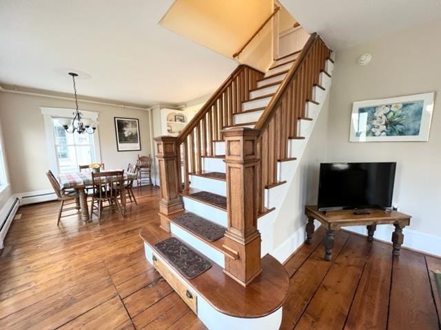 83 Maple St, Morristown, VT 05661 - stairs featuring hardwood / wood-style flooring, a chandelier, baseboards, and a baseboard heating unit