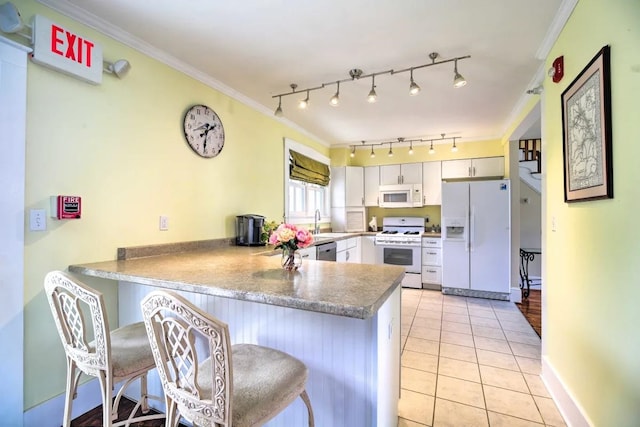 83 Maple St, Morristown, VT 05661 - kitchen featuring white appliances, a peninsula, a sink, ornamental molding, and light tile patterned floors