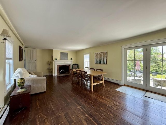83 Maple St, Morristown, VT 05661 - dining area with baseboard heating, wood-type flooring, a baseboard heating unit, ornamental molding, and a fireplace