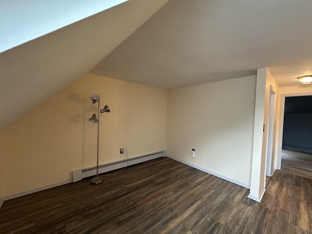 11 Pimlico Ct, Bedford, NH 03110 - additional living space featuring baseboard heating, dark wood-type flooring, a baseboard radiator, vaulted ceiling, and baseboards