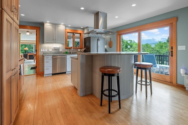 372 Brill Rd, Landaff, NH 03785 - kitchen featuring stainless steel appliances, island exhaust hood, a kitchen bar, light wood-style floors, and recessed lighting