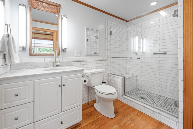 372 Brill Rd, Landaff, NH 03785 - bathroom featuring a shower stall, toilet, vanity, wood finished floors, and tile walls