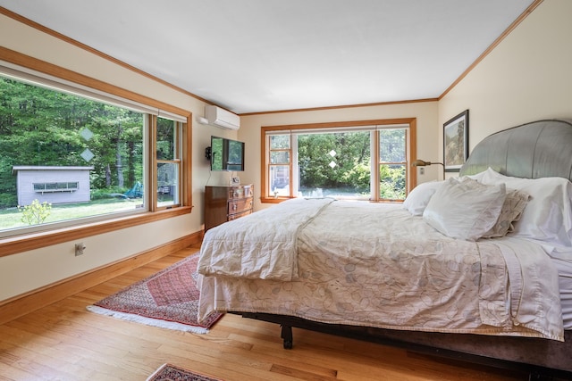 372 Brill Rd, Landaff, NH 03785 - bedroom with an AC wall unit, crown molding, wood finished floors, and baseboards
