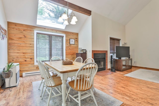 47 Trailside Ln Unit 18, Francestown, NH 03043 - dining space with high vaulted ceiling, a chandelier, a fireplace, light wood-style flooring, and wooden walls