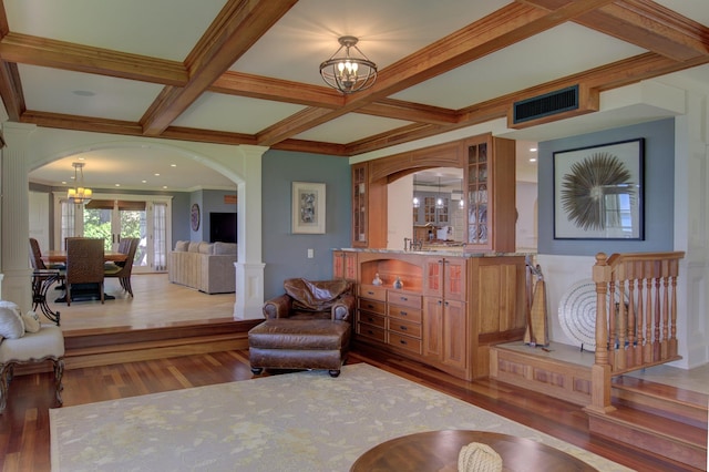194 Maquam Shore Rd, Swanton, VT 05488 - living area with a chandelier, arched walkways, wood finished floors, coffered ceiling, and beam ceiling