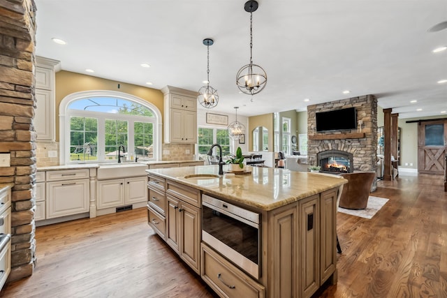 32 Burnham Rd, Windham, NH 03087 - kitchen with stainless steel microwave, a stone fireplace, recessed lighting, light stone counters, and a chandelier