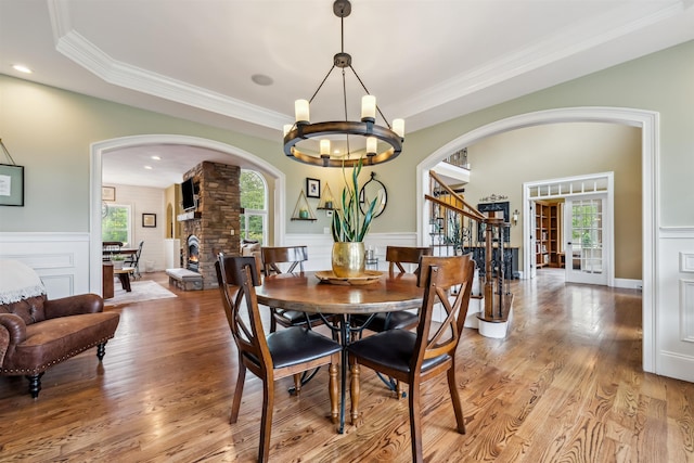 32 Burnham Rd, Windham, NH 03087 - dining room featuring arched walkways, plenty of natural light, a chandelier, stairway, and a wainscoted wall