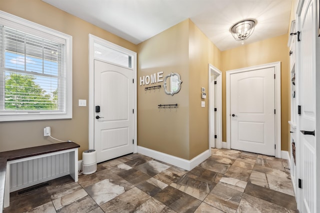 32 Burnham Rd, Windham, NH 03087 - entryway with stone finish floors, radiator heating unit, and a chandelier