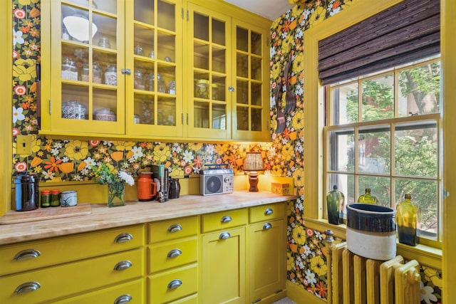 84 S Main St, Hanover, NH 03755 - kitchen featuring radiator heating unit, light countertops, glass insert cabinets, and wallpapered walls