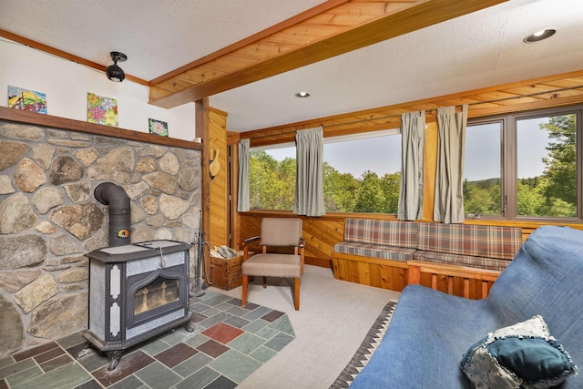794 Sawnee Bean Rd, Thetford, VT 05075 - living area featuring a wood stove, beamed ceiling, and dark colored carpet
