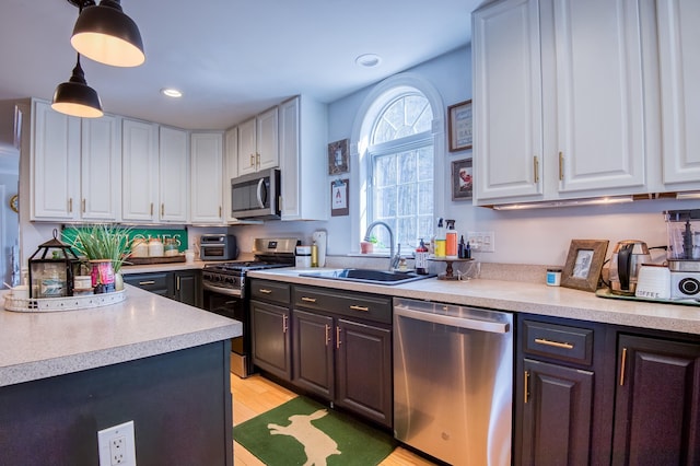 290 Elm St, Littleton, NH 03561 - kitchen with appliances with stainless steel finishes, white cabinetry, light countertops, light wood-type flooring, and decorative light fixtures