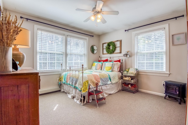 290 Elm St, Littleton, NH 03561 - bedroom with a wood stove, carpet floors, a baseboard radiator, and a ceiling fan