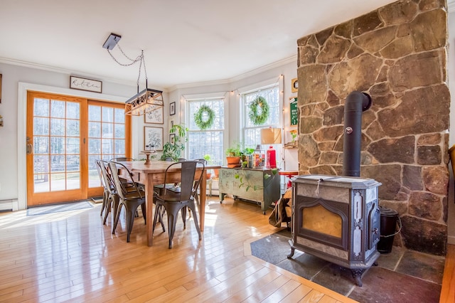 290 Elm St, Littleton, NH 03561 - dining space with ornamental molding, hardwood / wood-style flooring, and a wood stove