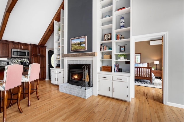 20 Bennett Cir, Antrim, NH 03440 - living area with a wall unit AC, light wood-style floors, a fireplace, and built in features
