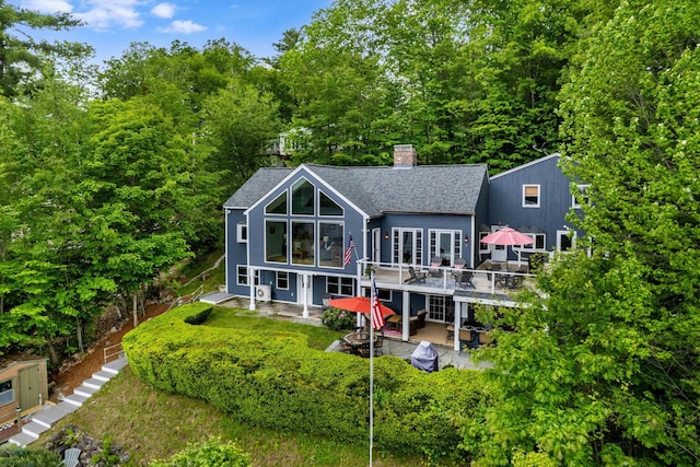 20 Bennett Cir, Antrim, NH 03440 - rear view of property featuring a patio, a chimney, a shingled roof, and a deck