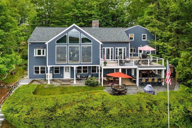 20 Bennett Cir, Antrim, NH 03440 - back of house featuring an outdoor fire pit, a chimney, a patio area, roof with shingles, and a wooden deck