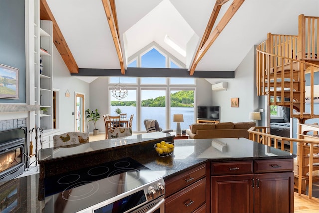 20 Bennett Cir, Antrim, NH 03440 - kitchen with stainless steel electric range oven, a wall mounted AC, open floor plan, high vaulted ceiling, and dark stone counters