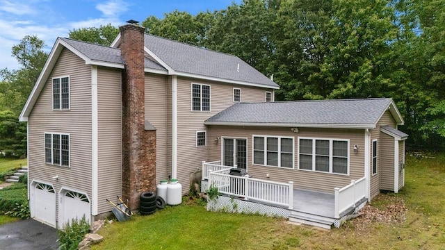 114 Byam Rd, New Boston, NH 03070 - back of property with a chimney, driveway, a shingled roof, and a yard