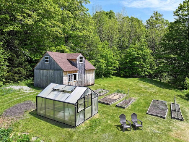 1074 N Hollow Rd, Rochester, VT 05767 - view of grassy yard featuring a garden, a greenhouse, an outbuilding, and a view of trees
