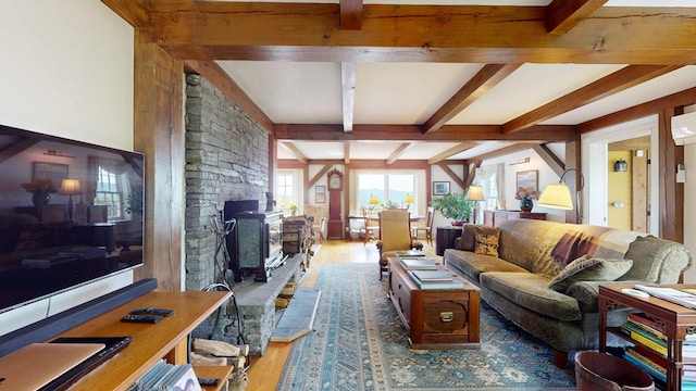 1074 N Hollow Rd, Rochester, VT 05767 - living area with wood finished floors, beam ceiling, and a wood stove