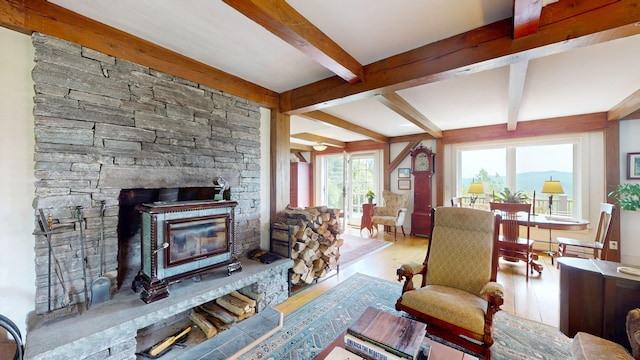 1074 N Hollow Rd, Rochester, VT 05767 - living room featuring beamed ceiling, wood finished floors, and a stone fireplace