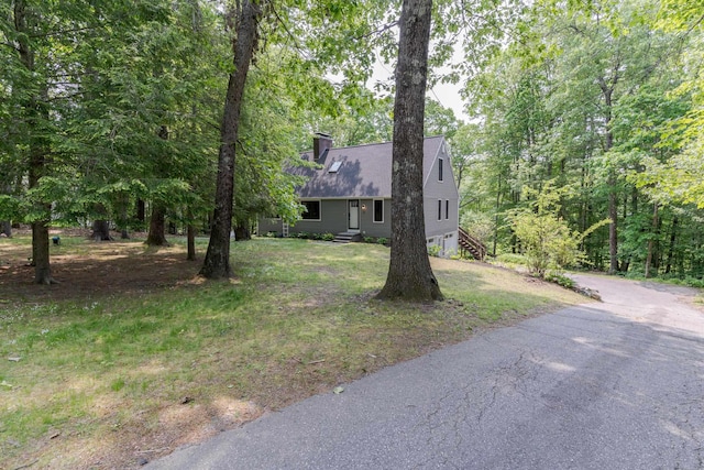 12 Garrison Ln, Madbury, NH 03823 - cape cod house featuring driveway, a chimney, a shingled roof, and a front yard