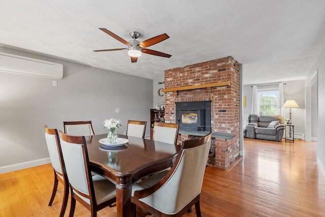 10 Jeremy Hill Rd, Pelham, NH 03076 - dining area with a wall mounted air conditioner, a ceiling fan, baseboard heating, light wood-style floors, and a fireplace