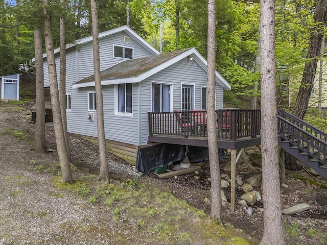 23 E Shore Dr, Greene, ME 04236 - view of front facade featuring a deck, roof with shingles, and view of wooded area