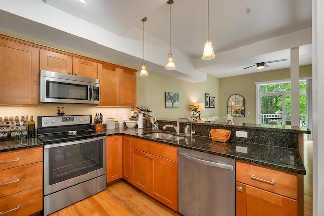 116 Piscataqua Rd Unit C, Durham, NH 03824 - kitchen with stainless steel appliances, a peninsula, light wood finished floors, brown cabinets, and hanging light fixtures