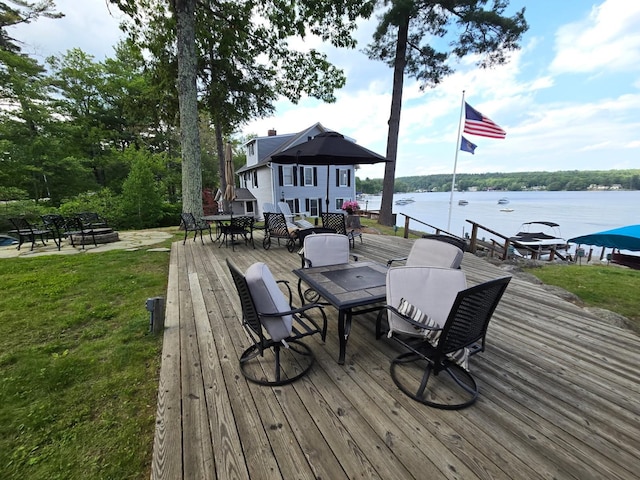 596 Endicott St, Laconia, NH 03246 - wooden terrace featuring outdoor dining space, a water view, and a lawn