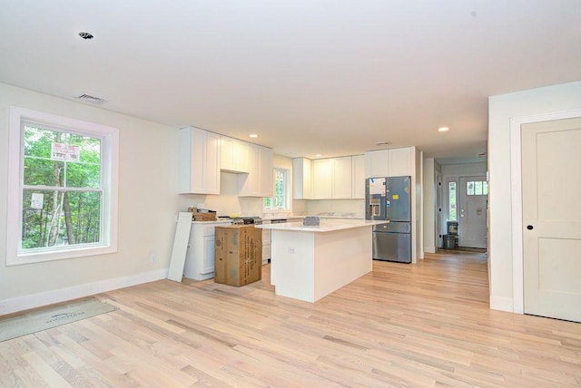 19 Speare Rd Unit B, Hudson, NH 03051 - kitchen with stainless steel fridge, light wood finished floors, white cabinets, light countertops, and a center island