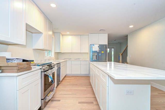 19 Speare Rd Unit B, Hudson, NH 03051 - kitchen with stainless steel appliances, a kitchen island, light wood finished floors, recessed lighting, and light stone counters