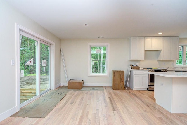 19 Speare Rd Unit B, Hudson, NH 03051 - kitchen with stainless steel gas range oven, light countertops, light wood-style flooring, white cabinets, and recessed lighting