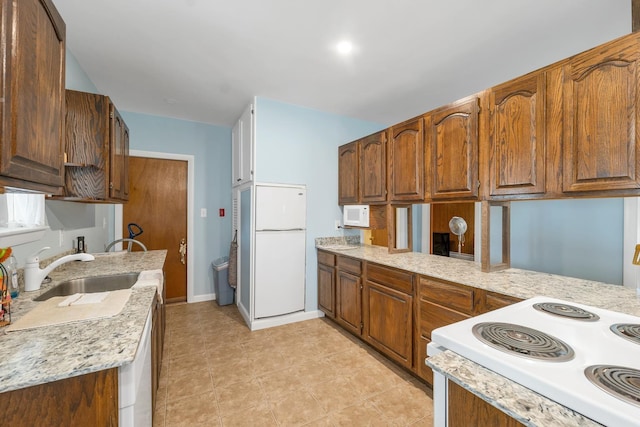 906 N Main St, Laconia, NH 03246 - kitchen with white appliances, light tile patterned floors, and brown cabinetry