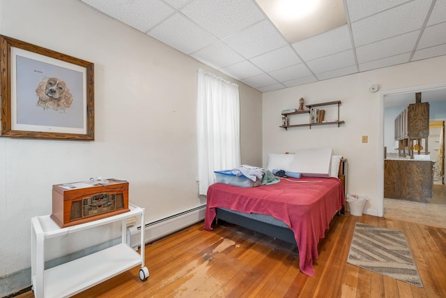 906 N Main St, Laconia, NH 03246 - bedroom featuring a baseboard radiator, hardwood / wood-style floors, and a paneled ceiling