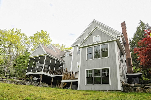 2 Parker Farm Ln, Amherst, NH 03031 - back of property with a sunroom, a chimney, and a wooden deck
