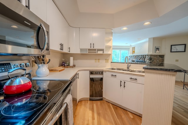 58 Bunker Ln Unit 3, Lincoln, NH 03251 - kitchen with stainless steel appliances, open shelves, light wood-style flooring, recessed lighting, and white cabinetry