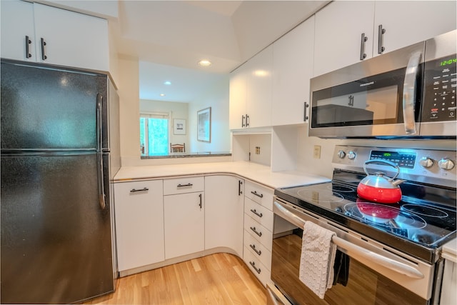 58 Bunker Ln Unit 3, Lincoln, NH 03251 - kitchen with stainless steel appliances, light countertops, light wood finished floors, white cabinets, and recessed lighting