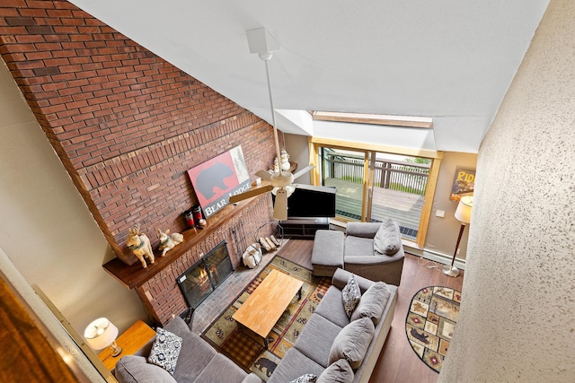 105 Timberline Rd S Unit L8, Killington, VT 05751 - living area featuring a brick fireplace, a high ceiling, wood finished floors, and a baseboard heating unit