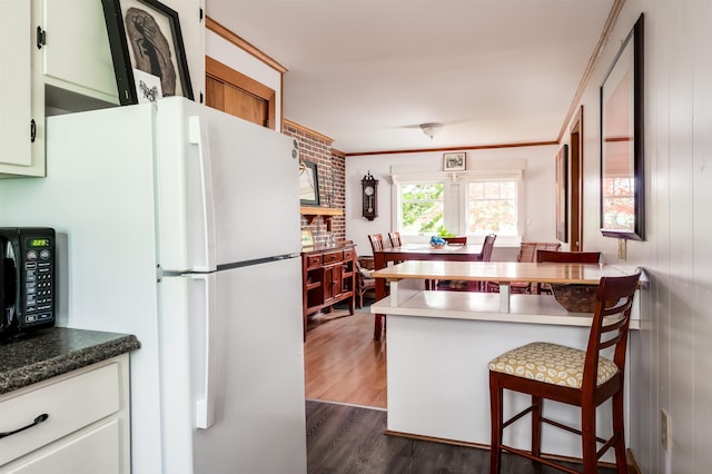 30 Old Piscataqua Rd, Durham, NH 03824 - kitchen with freestanding refrigerator, black microwave, dark wood-style floors, a breakfast bar area, and a peninsula