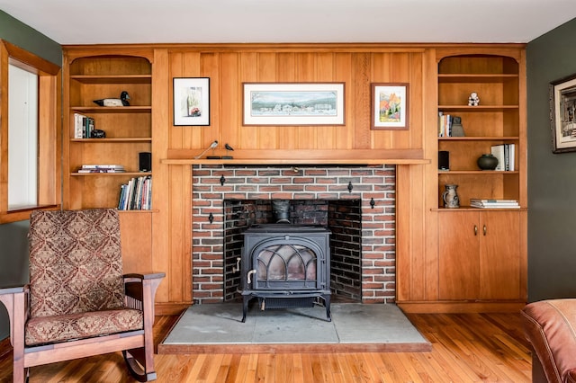 30 Old Piscataqua Rd, Durham, NH 03824 - living area with wood finished floors, a wood stove, built in shelves, and wood walls
