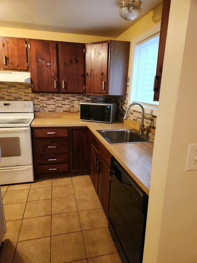 17 Burns Ave Unit 2, Concord, NH 03301 - kitchen with black appliances, under cabinet range hood, backsplash, light countertops, and light tile patterned flooring