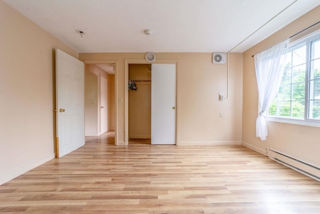 30 Beech St Unit 4B, Bristol, NH 03222 - unfurnished room with a baseboard radiator, light wood finished floors, and a smoke detector