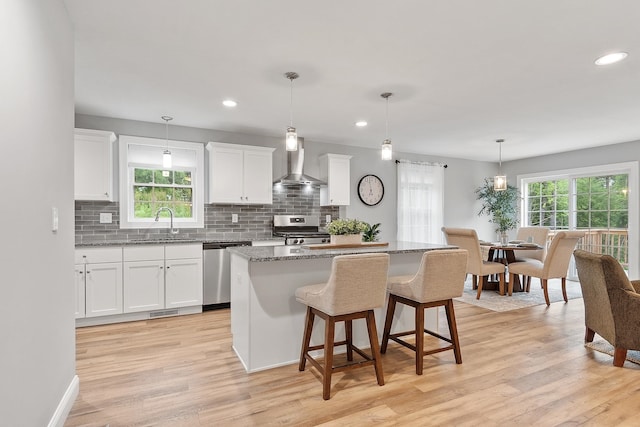 7A Terraceview Dr, Hudson, NH 03051 - kitchen featuring wall chimney range hood, appliances with stainless steel finishes, decorative backsplash, white cabinetry, and recessed lighting