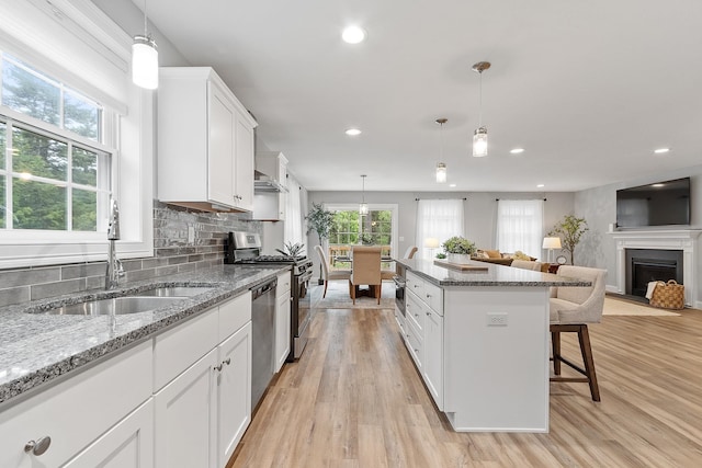 7A Terraceview Dr, Hudson, NH 03051 - kitchen featuring a breakfast bar area, recessed lighting, open floor plan, white cabinets, and stainless steel appliances
