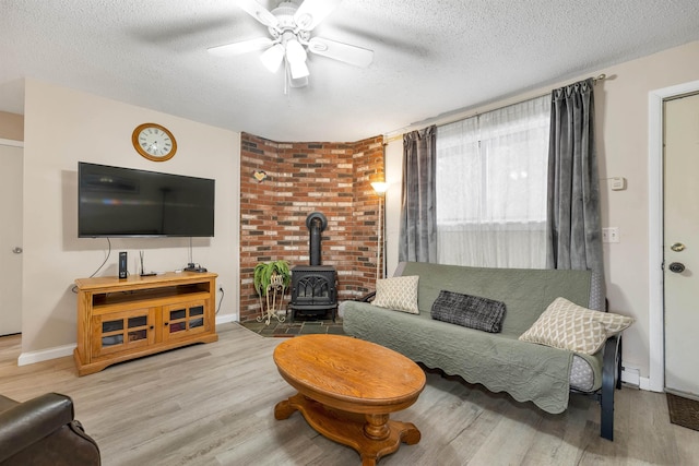 42 Wylie Ct Unit 6, Conway, NH 03860 - living area featuring a wood stove, ceiling fan, wood finished floors, and a textured ceiling