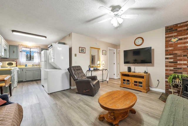 42 Wylie Ct Unit 6, Conway, NH 03860 - living area featuring light wood-style floors, a textured ceiling, a ceiling fan, and stacked washing machine and dryer