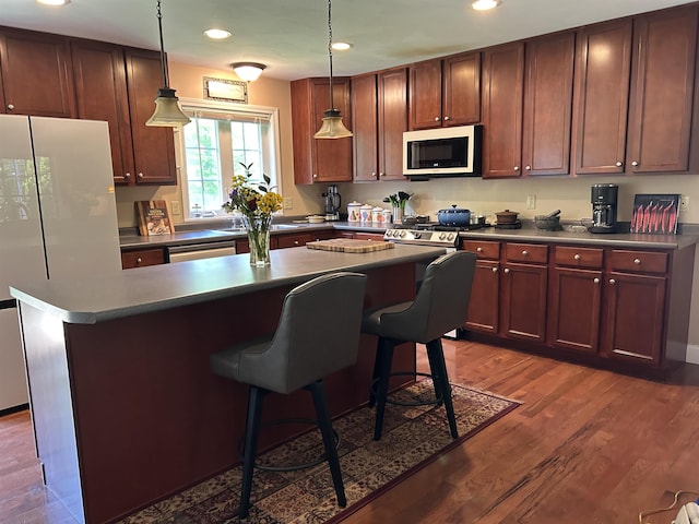 142 Eagle Shore Rd, Moultonborough, NH 03254 - kitchen with white appliances, dark countertops, a kitchen island, a breakfast bar, and recessed lighting